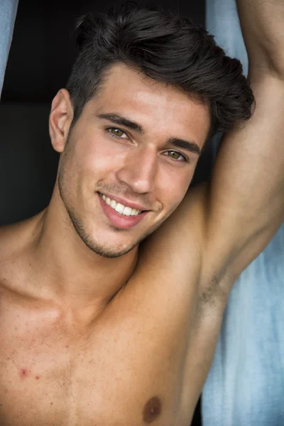 Sexy young man standing shirtless by curtains — Stock Photo, Image