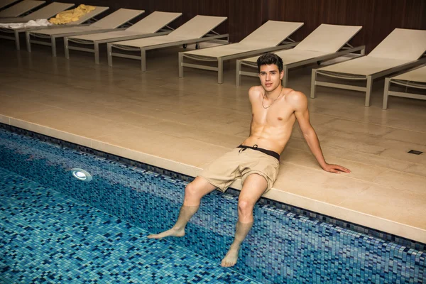 Hermosa camisa hombre joven se sienta en la piscina — Foto de Stock