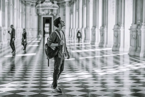 Hombre guapo con una guía dentro de un museo — Foto de Stock