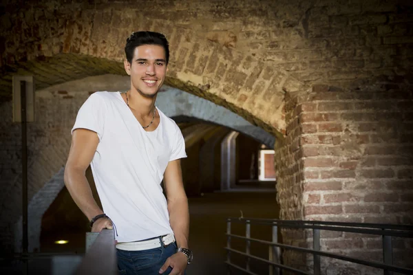 Handsome young man in old building smiling — kuvapankkivalokuva