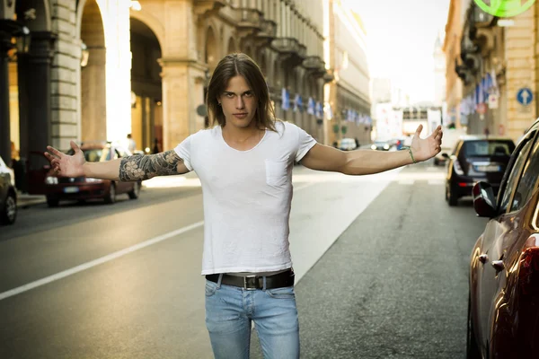 Uomo con le braccia aperte in piedi in strada — Foto Stock
