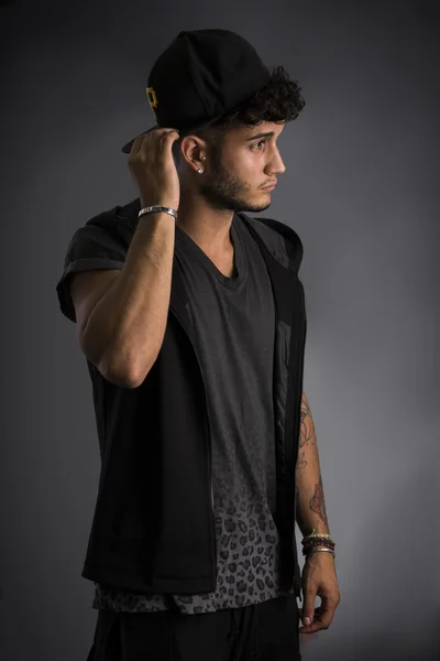 Profile of handsome young man in dark t-shirt and baseball hat — Stock Photo, Image