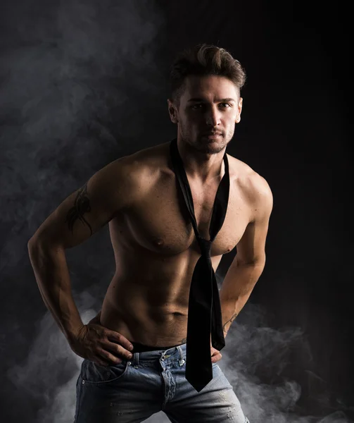 Handsome shirtless muscular man standing on dark background — Stock Photo, Image