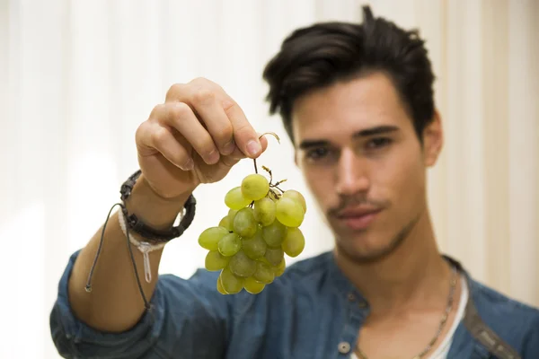 Junger Mann hält einen großen leckeren Reifen Haufen Trauben — Stockfoto