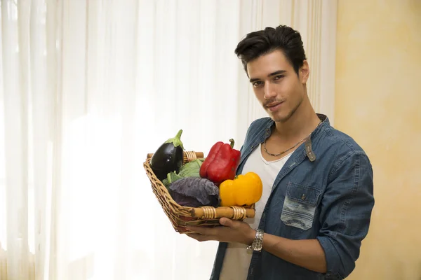 年轻人提着一篮新鲜的蔬菜，健康的饮食概念 — 图库照片