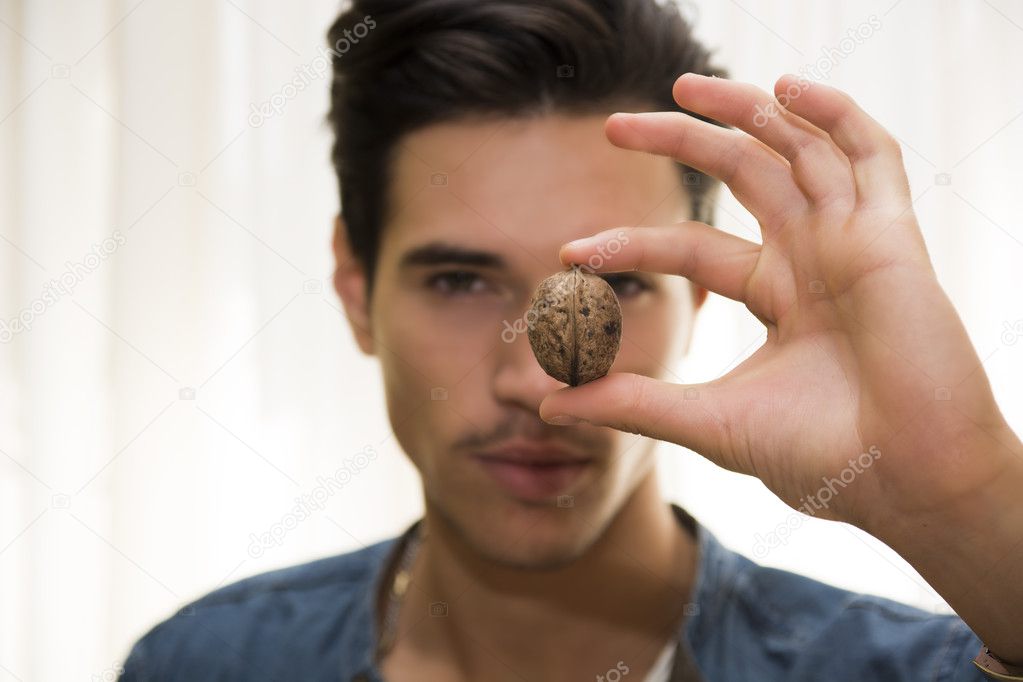 Young man holding a large delicious nut