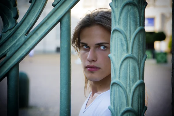 Gorgeous Long Hair Man behind Metal Bars — Stock Photo, Image