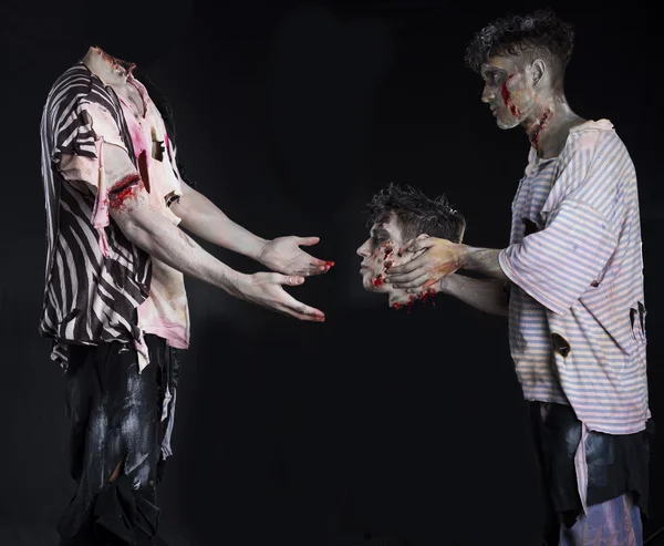 Zombies hombres dos, uno dando la cabeza decapitada al cuerpo de —  Fotos de Stock