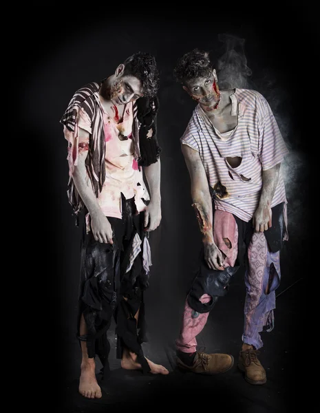 Deux zombies mâles debout sur fond noir, pleine longueur — Photo