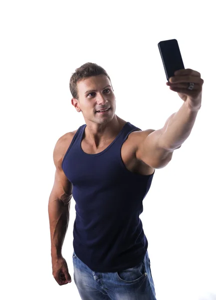 Handsome muscular young man taking selfie with cell phone, isolated — Stock Photo, Image