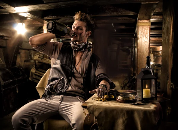 Пират, пьющий от, разливает по бутылкам четверти судна — стоковое фото
