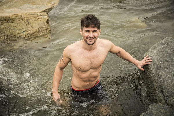 Handsome young muscle man standing in water pond, shirtless — Stock Photo, Image