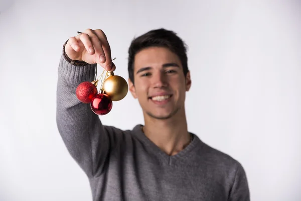 Jovem atraente segurando bolas de árvore de Natal — Fotografia de Stock