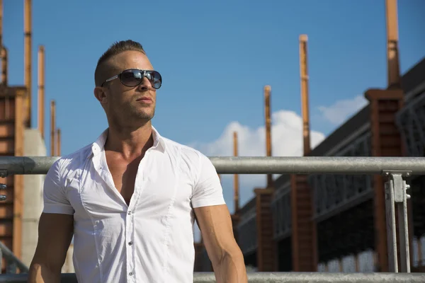 Bonito homem loiro musculoso permanente no ambiente de cidade — Fotografia de Stock