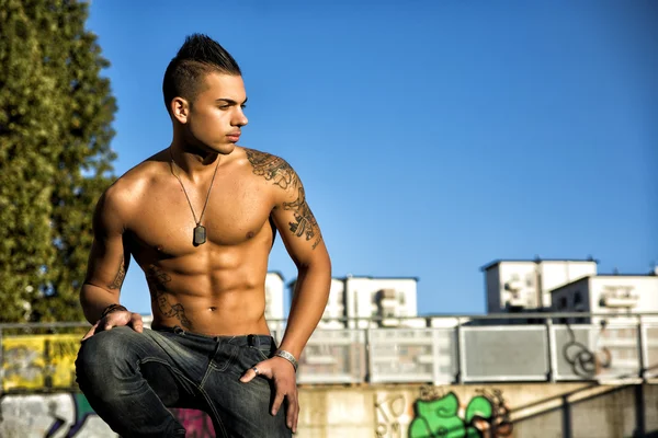 Handsome fit athletic shirtless young man in city setting — Stock Photo, Image