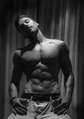Yakışıklı gömleksiz kaslı adamın dramatik ışık ile