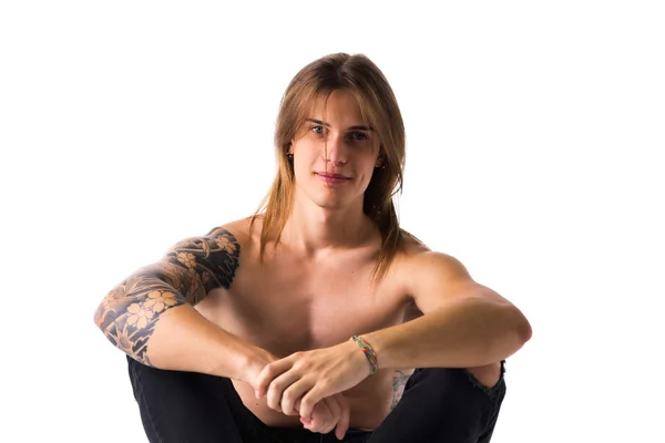 Attractive young man with long hair shirtless, sitting, isolated — Stock Photo, Image