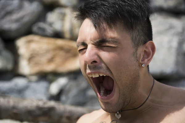 Beau jeune homme bâillement en plein air — Photo