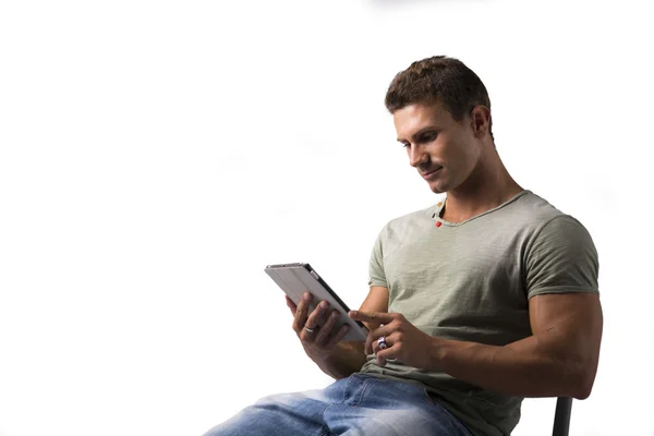 Jovem, segurando o leitor de ebook, sentado a sorrir — Fotografia de Stock