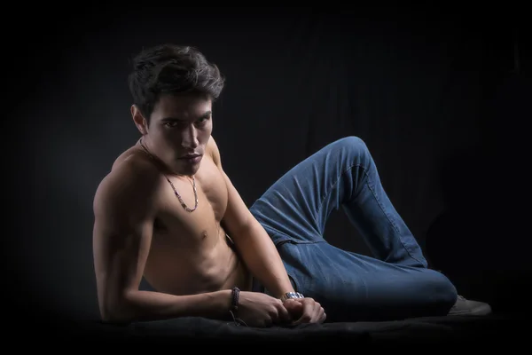 Красивый мускулистый молодой человек без рубашки, ложащийся на полу — стоковое фото