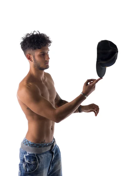 Модный молодой человек, уравновешивающий кепку на его пальце — стоковое фото