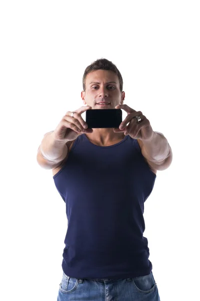 Красивый мускулистый молодой человек, делающий селфи с сотовым телефоном — стоковое фото