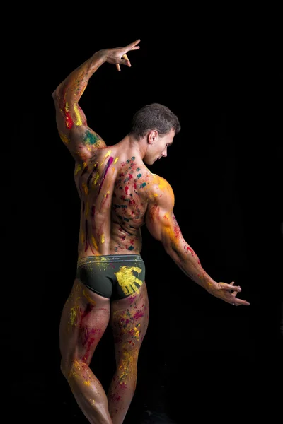 Back of muscular man with skin painted with Holi colors — Stock Photo, Image