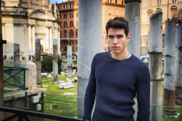 Молодой человек в Риме, стоящем перед foro traiano и fori imperiali — стоковое фото