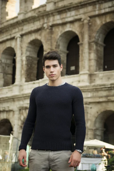 Pohledný mladý muž v Římě stojící před Koloseum — Stock fotografie