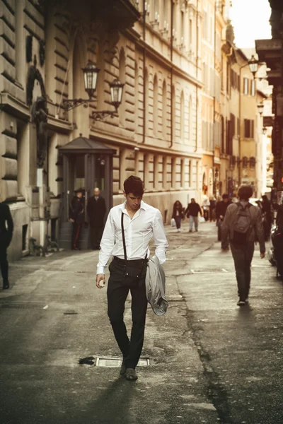 Handsome young man walking in European city street — стоковое фото