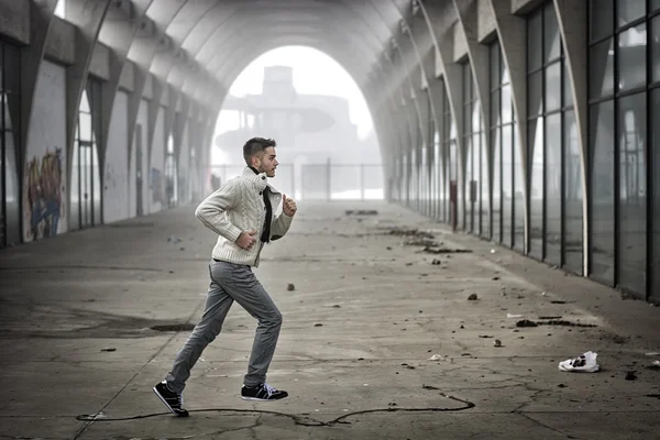 Hombre corriendo a través del túnel abandonado — Foto de Stock