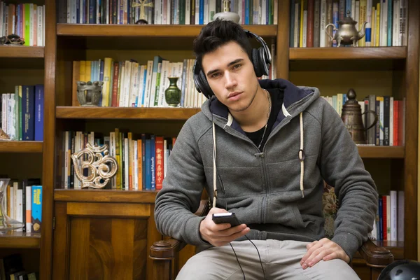 Aantrekkelijke jonge man zitten luisteren naar muziek — Stockfoto