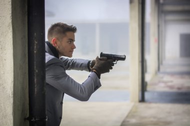 Yakışıklı genç Dedektif ya da bir silah tutan polis