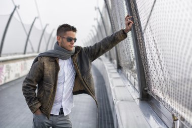 Bir köprü üzerinde duran, aşağı bakıyor trendy yakışıklı