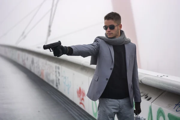 Young detective or policeman or mobster firing a gun — Stock Photo, Image