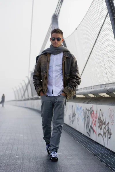 Homem bonito na moda, andando sobre uma ponte — Fotografia de Stock