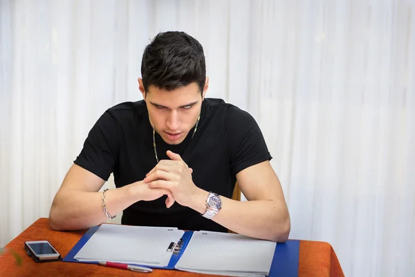 Young man studying or working at home with diabolical face — Stock Photo, Image