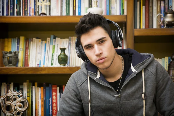 Müzik kulaklık çekici genç adam evde dinlemek — Stok fotoğraf