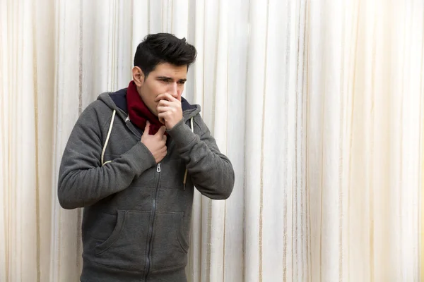 Больной молодой человек с гриппом или простудой, кашляя — стоковое фото