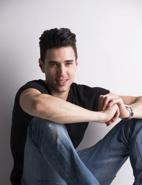 Handsome young man sitting on the floor — Stock Photo, Image