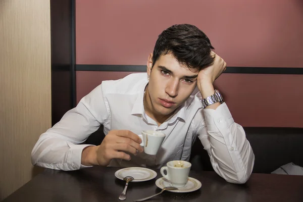 Benadrukt Man met een kopje koffie aan de tafel — Stockfoto