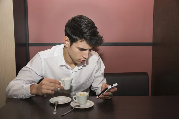 Hombre tomando café mirando el teléfono móvil — Foto de Stock