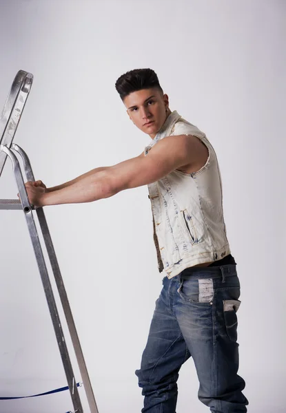 Young man leaning on metal ladder — Stock Photo, Image