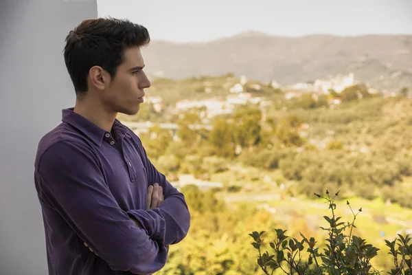 Young man standing looking over a rural landscape — Stock Photo, Image