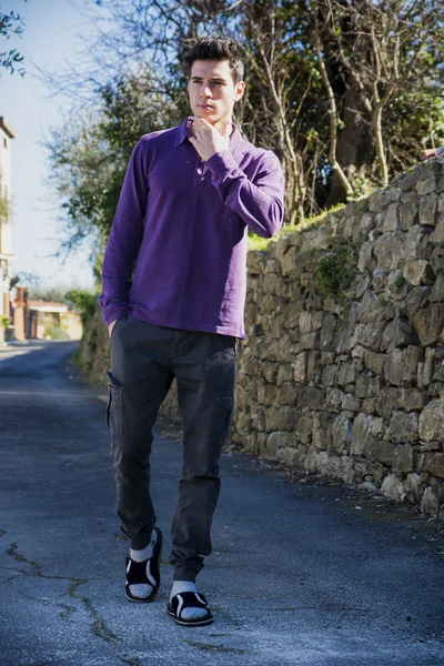 Young man walking along rural road — Stock Photo, Image