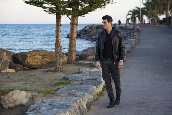 Handsome man at the seaside along the shore — Stock Photo, Image