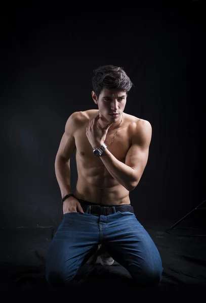 Handsome muscular shirtless young man kneeling down on the floor — Stock Photo, Image