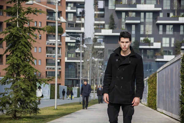 Uomo alla moda in cappotto nero in piedi in città — Foto Stock