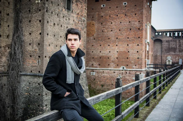 Giovane uomo all'esterno dell'edificio che distoglie lo sguardo a sinistra — Foto Stock