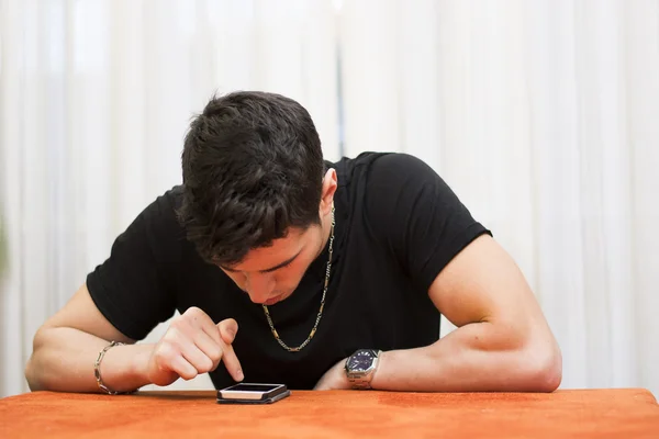 Young man typing a text message on his phone — Stock Photo, Image